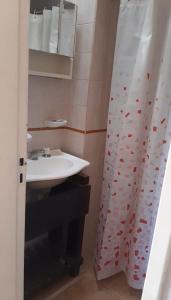 a bathroom with a sink and a shower curtain at Ruka Leufu in Santa Rosa de Calamuchita