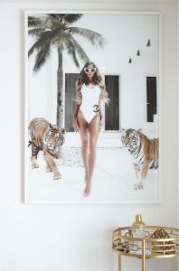 a woman in a white dress standing in front of two tigers at The Villa's Mooloolaba in Mooloolaba