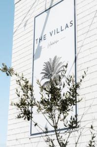 a sign on the side of a building with a palm tree at The Villa's Mooloolaba in Mooloolaba