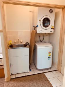 a small kitchen with a sink and a washing machine at Royal Albert Hotel in Brisbane