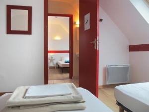 a room with two beds and an open door at Gîte Les Pingouins de l'Aber in Brélès