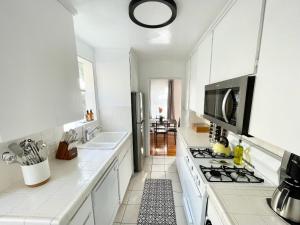 a white kitchen with a stove and a sink at 2 Bedroom - Ocean View Hot Tub Parking - 8 Guest in San Diego