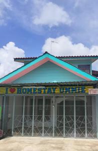 a building with a sign on the top of it at Homestay Ummie 