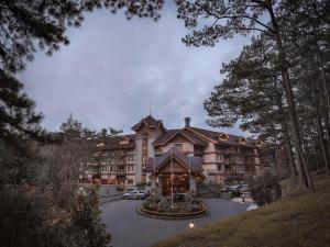 a large resort building in the middle of a parking lot at Private Rooms and Cabins in Camp John Hay Baguio in Baguio