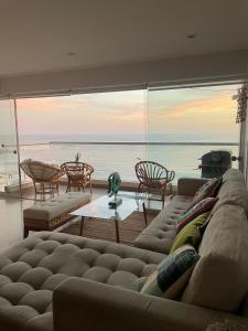 a living room with a couch and a view of the ocean at Apartamento Playa Señoritas in Punta Hermosa