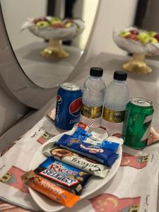 uma mesa com snacks e garrafas de água em شقق ارجان نجد المفروشه em Al Nairyah