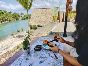 Una donna seduta a un tavolo con un piatto di cibo di Riu del Mar Hostel a Dauis