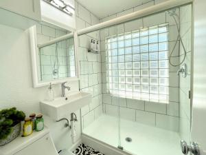 ein weißes Bad mit einem Waschbecken und einer Dusche in der Unterkunft Hidden Gem with Hot Tub and Parking - 4 Guests in San Diego