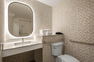 a bathroom with a sink and a toilet and a mirror at Holiday Inn Ontario, an IHG Hotel in Ontario