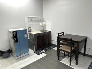 a small kitchen with a table and a refrigerator at Muangthong p2 in Ban Song Hong