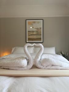 dos cisnes de toalla sentados en la parte superior de una cama en Tayy’s Inn, en Birmingham