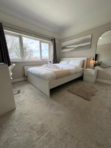 ein Schlafzimmer mit einem großen Bett und einem großen Fenster in der Unterkunft Tayy’s Inn in Birmingham
