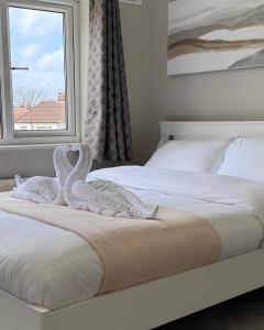 una camera da letto con 2 asciugamani cigni su un letto di Tayy’s Inn a Birmingham