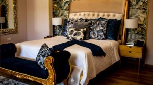 a bedroom with a large bed and a chair at Hotel Mansion Sant Serrant Medellín- Aeropuerto Rionegro in Marinilla