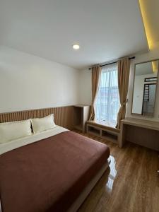 1 dormitorio con cama y ventana grande en Bamboosa, en Bukittinggi