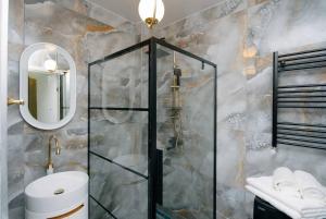 une salle de bain avec douche, toilettes et miroir dans l'établissement Steps Batumi - One Bedroom corner unit ocean view, à Batoumi 39 autres photos