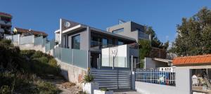 a house on a hill with a blue gate at Luxury Villa M in Rogoznica