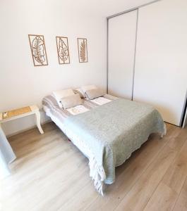 a white bedroom with a bed and a wooden floor at Amplio dúplex en Lomas con cochera in Lomas de Zamora