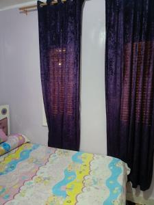 a bedroom with purple curtains and a bed at شقه مفروشه فرش فندقي بمدينه العبور الحي الراقي فيو حديقه in ‘Ezbet el-Insha