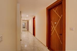un corridoio con porta in legno e un corridoio con corridoio di Super OYO Flagship Red Diamond Hotel a Ghaziabad