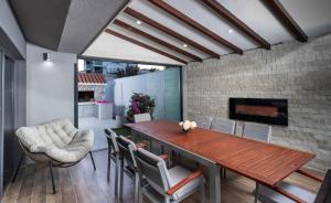a dining room with a table and chairs and a fireplace at Luxury Villa M in Rogoznica