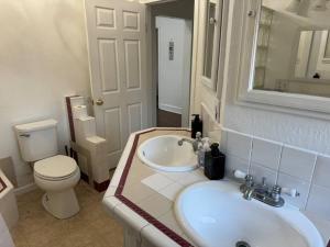 a white bathroom with a toilet and a sink at Spacious Downtown Home SJ in San Jose