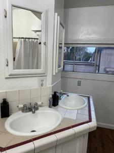 a bathroom with two sinks and a mirror at Spacious Downtown Home SJ in San Jose