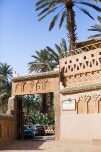 a gate to a villa with a palm tree at Riad Tabhirte in Agdz