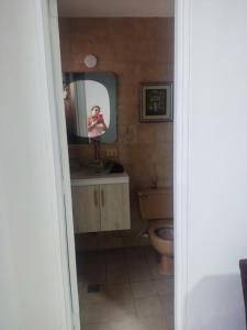 una persona que toma una foto de un baño con espejo en Apartamentos cerca ala basílica, en Buga