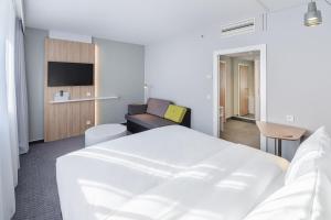 een hotelkamer met een bed en een bank bij Holiday Inn Express Dresden Zentrum, an IHG Hotel in Dresden