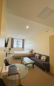 a living room with a couch and a table at Grand Central Serviced Apartments in Auckland
