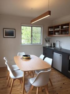 Una cocina y un comedor con mesa y sillas de madera. en Lago, en Manyana
