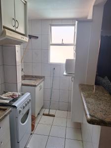 a small kitchen with a stove and a window at Apartamento Millenium Thermas Residence 103 - B in Caldas Novas