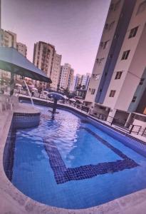 a large blue swimming pool in the middle of a city at Apartamento Millenium Thermas Residence 103 - B in Caldas Novas