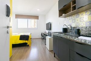 una cocina con fregadero y una cama en una habitación en Tranquilo Studio no Brás com Piscina/Metrô Brás, en São Paulo