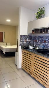 uma cozinha com um lavatório e uma cama num quarto em Hospedaria Ilhéus 01 em Ilhéus