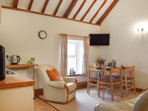 a kitchen and living room with a table and chairs at The Bothy in Whitland