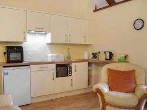 a kitchen with a chair and a microwave at The Bothy in Whitland