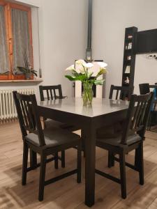 een eettafel met stoelen en een vaas met bloemen bij SERENDIPITY B&b in Fabriano