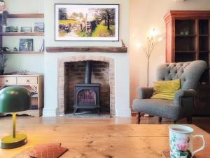 a living room with a fireplace and a chair at Little Hills in Keswick