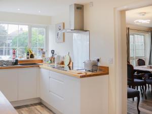 a kitchen with white cabinets and a counter top at The Moorings in Rhyl