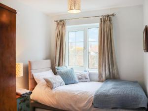uma cama num quarto com uma janela em The Moorings em Rhyl