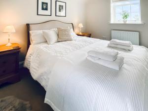 una camera da letto con un letto bianco e asciugamani di The Old Court House a Silloth