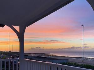 d'un balcon offrant une vue sur la plage au coucher du soleil. dans l'établissement Beach View House, à Margate