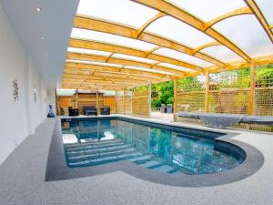 una piscina cubierta con techo de madera y una piscina en Apple-uk46285, en Camerton