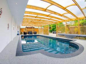 an indoor swimming pool with a wooden ceiling and a swimming poolvisor at Maple - Uk46284 in Camerton