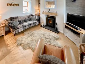 a living room with a couch and a fireplace at Yardie View in Buckie