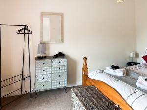 um quarto com uma cama e uma cómoda com um espelho em Roseus - Uk44706 em Combe Martin