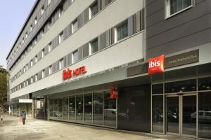 a woman walking in front of a building at ibis London Shepherds Bush - Hammersmith in London