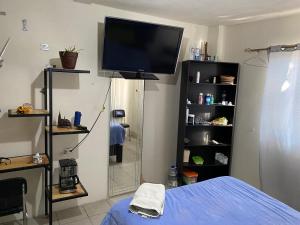 - une chambre avec une télévision murale et un lit dans l'établissement Habitación privada Leonera, à Cholula